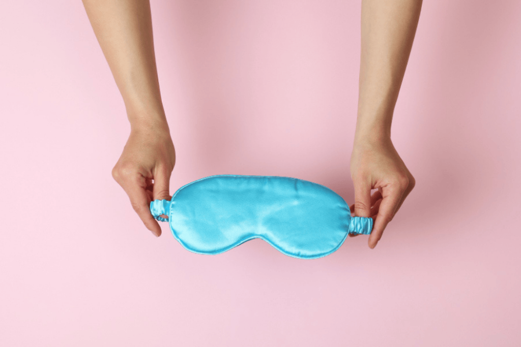 Weighted Sleep Masks-wcvendors - WC Vendors Person holding a blue weighted sleep mask against a pastel pink background